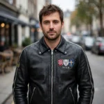 Model wearing the Buick Leather Jacket, midnight black with tri-shield-style chest emblem racer jacket