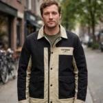 Man wearing the Defender Leather Jacket outdoors, front-facing, showing the trucker jacket and chest embroidery